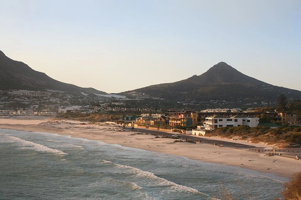 Waves washing onto Hout Bay’s sandy beach beneath the mountains